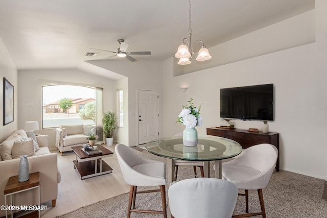 dining space featuring ceiling fan with notable chandelier, lofted ceiling, and visible vents