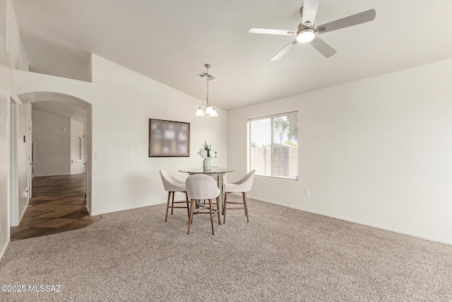 dining area with carpet floors, arched walkways, ceiling fan with notable chandelier, lofted ceiling, and visible vents