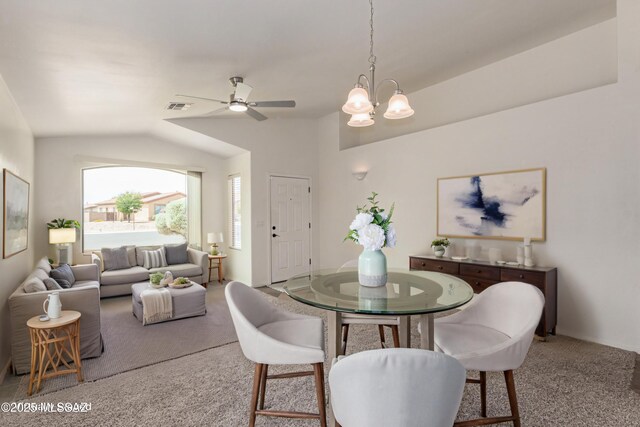 dining area featuring ceiling fan with notable chandelier, carpet, lofted ceiling, and visible vents
