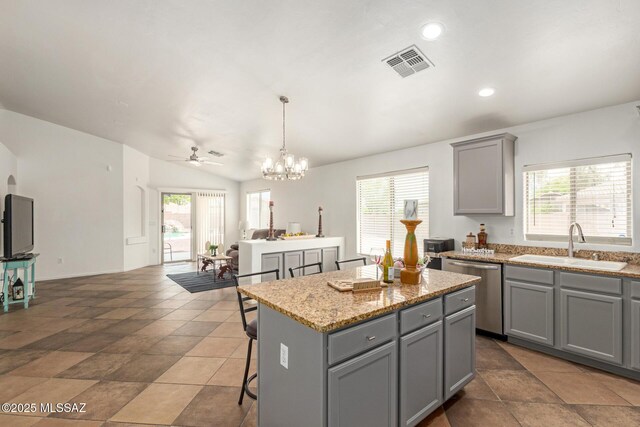 kitchen featuring gray cabinets, visible vents, a center island, stainless steel dishwasher, and a sink