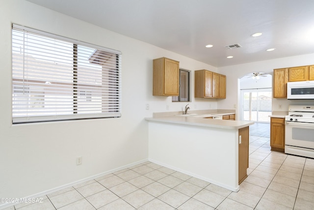 kitchen featuring white appliances, light countertops, a sink, recessed lighting, and a ceiling fan