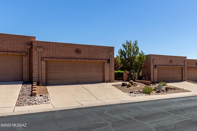 view of front facade featuring a garage, brick siding, and driveway
