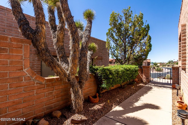 view of property exterior with fence and a gate