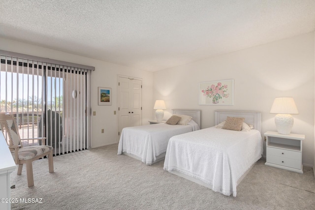 bedroom featuring a textured ceiling, carpet flooring, and access to outside
