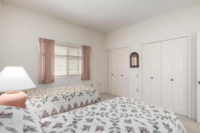 bedroom featuring two closets and light carpet
