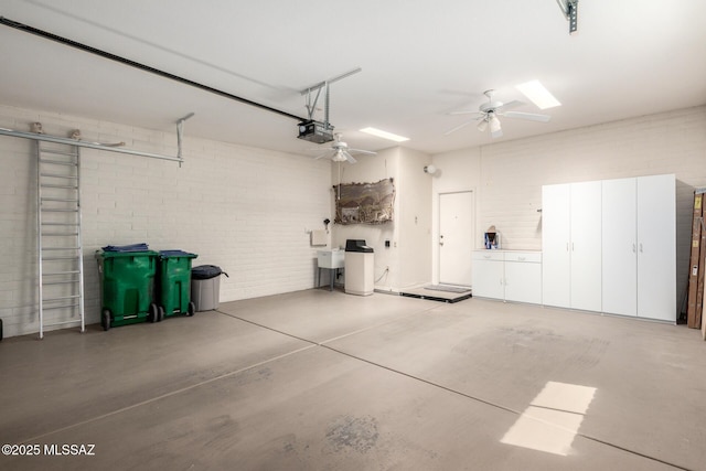 garage featuring a garage door opener, a ceiling fan, and a sink
