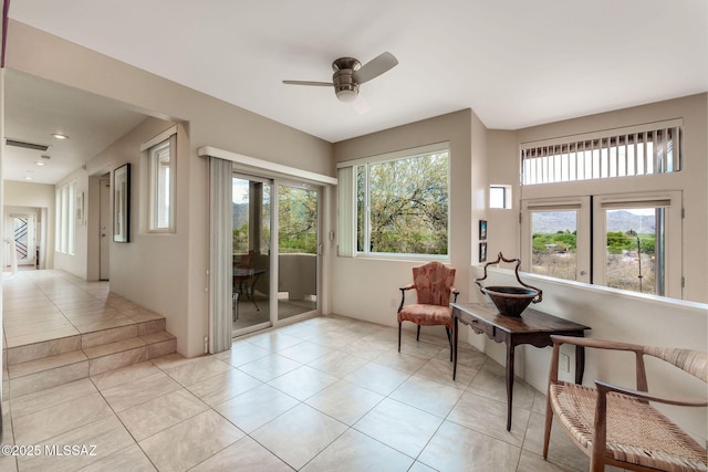 living area with a ceiling fan and light tile patterned flooring