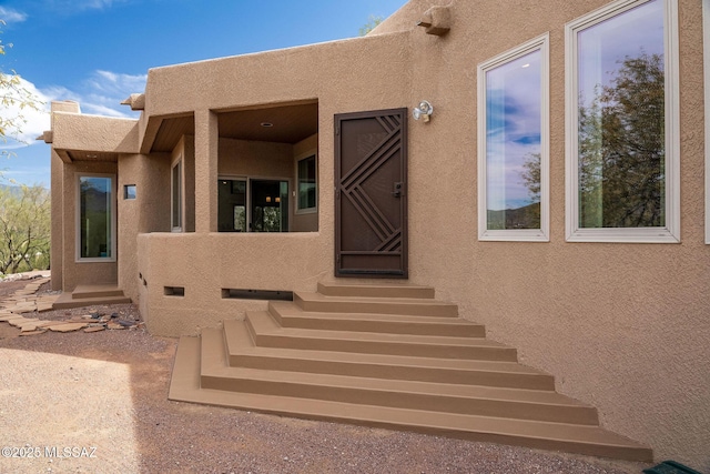 view of exterior entry featuring stucco siding