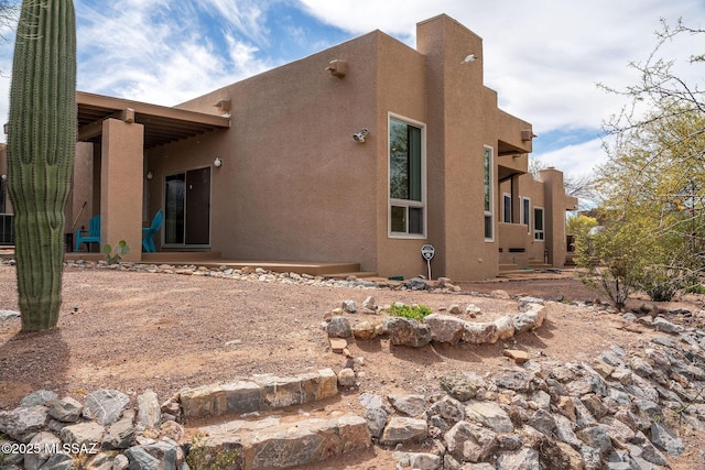 back of property featuring stucco siding