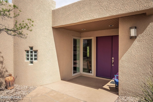 doorway to property with a patio and stucco siding