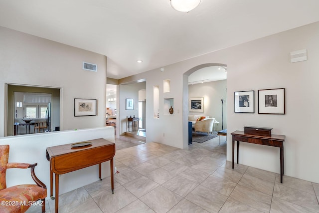 hall featuring visible vents, recessed lighting, and arched walkways