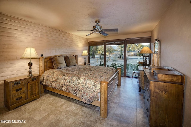 bedroom featuring a textured ceiling, access to exterior, and a ceiling fan
