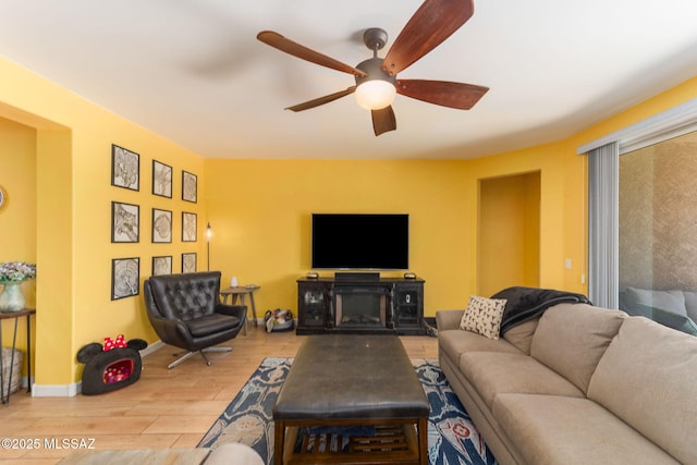 living area with ceiling fan, baseboards, and wood finished floors