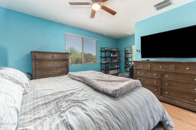 bedroom with ceiling fan, light wood-style floors, and visible vents