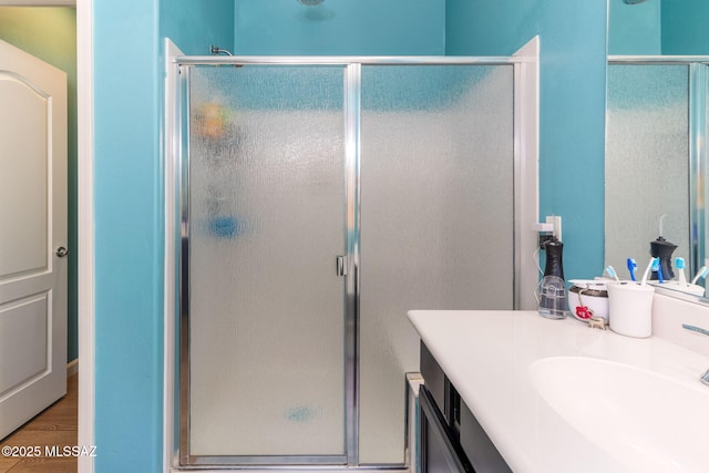 full bath featuring a shower stall, vanity, and wood finished floors