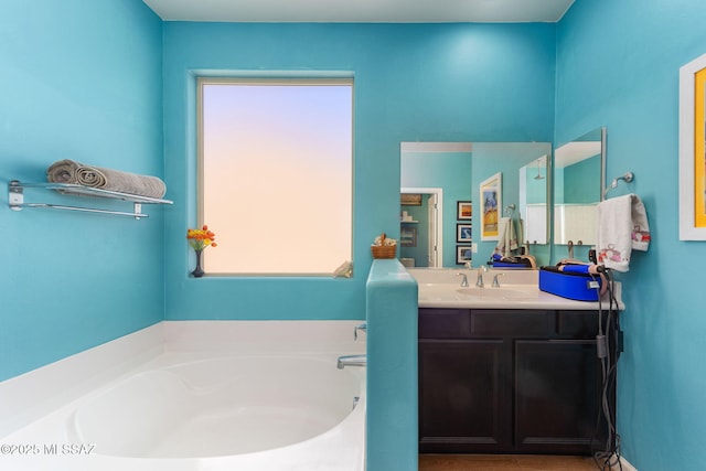 full bathroom featuring a garden tub and vanity