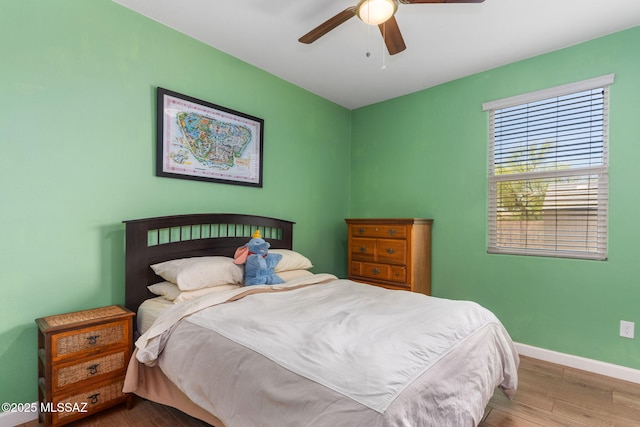 bedroom featuring baseboards, a ceiling fan, and wood finished floors
