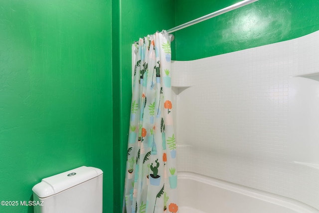 bathroom featuring shower / tub combo and toilet