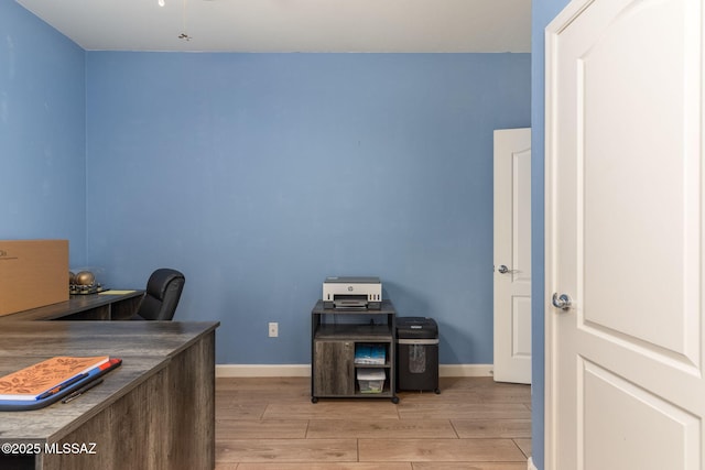home office with baseboards and light wood finished floors