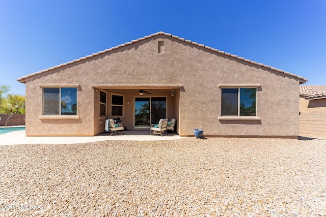 back of property with a ceiling fan, a patio area, stucco siding, and fence