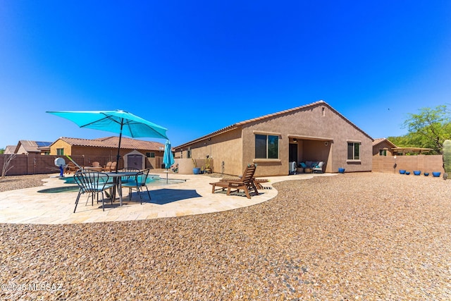 exterior space with a patio area, a fenced backyard, an outbuilding, and a shed