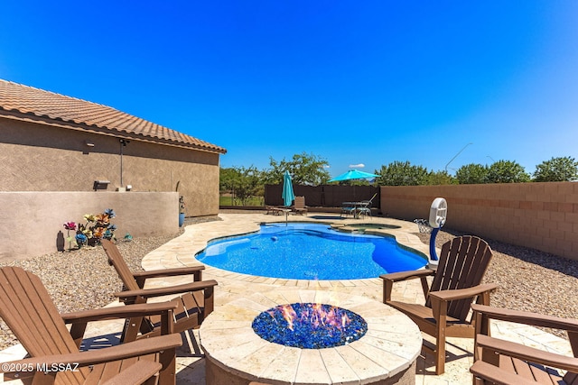 view of swimming pool with a fenced in pool, a fenced backyard, a patio, and an outdoor fire pit