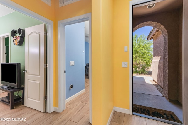 foyer entrance featuring light wood finished floors and baseboards