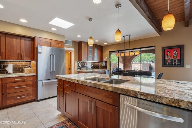 kitchen featuring backsplash, visible vents, stainless steel appliances, and a sink