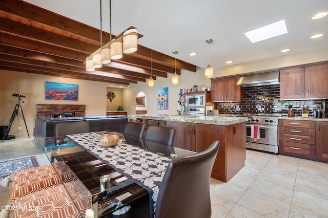 kitchen featuring tasteful backsplash, stainless steel appliances, beamed ceiling, wall chimney exhaust hood, and light stone countertops