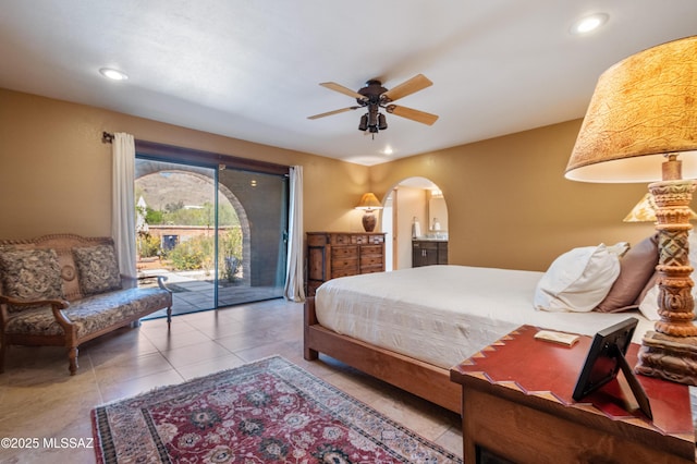 tiled bedroom with a ceiling fan, arched walkways, recessed lighting, and access to exterior