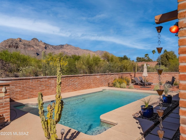 view of swimming pool with fence, a patio area, a fenced in pool, and a mountain view
