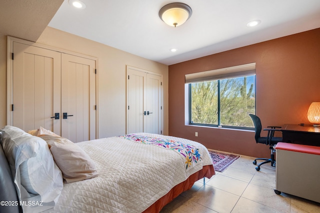 bedroom with light tile patterned floors, multiple closets, and recessed lighting