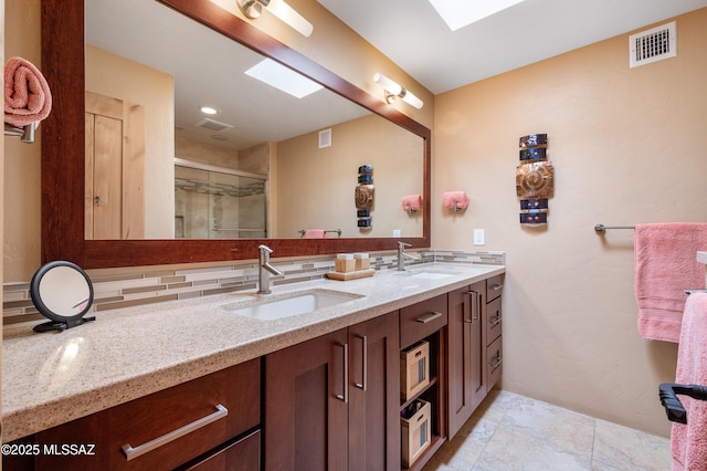full bath featuring decorative backsplash, visible vents, a sink, and double vanity