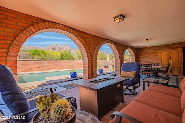 view of patio with outdoor dining area, a fenced backyard, a mountain view, an outdoor living space with a fire pit, and a fenced in pool