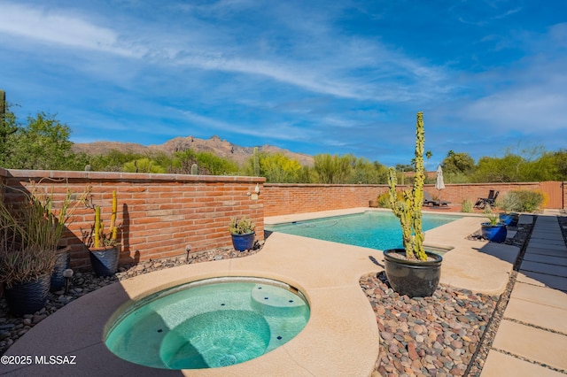 view of pool with a fenced in pool, a fenced backyard, a mountain view, an in ground hot tub, and a patio