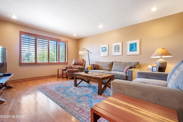 living area featuring baseboards, wood finished floors, and recessed lighting