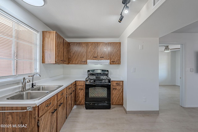 kitchen with range hood, a sink, black range with gas stovetop, brown cabinetry, and light countertops
