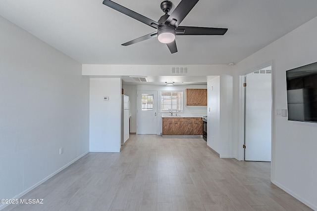 unfurnished living room with visible vents, a ceiling fan, and light wood-style flooring