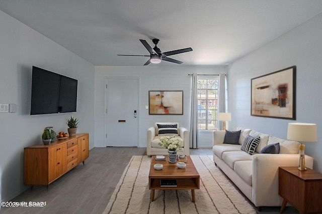 living area with a ceiling fan and light wood-style flooring