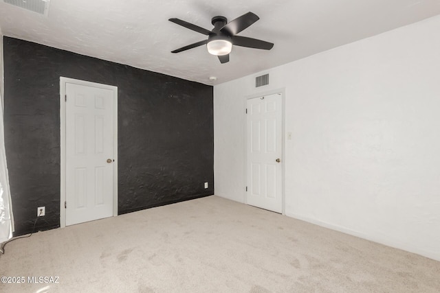 spare room with ceiling fan and carpet