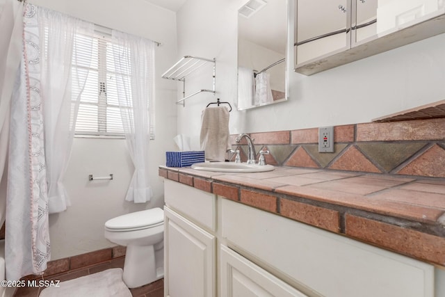 bathroom featuring toilet, vanity, curtained shower, and baseboards