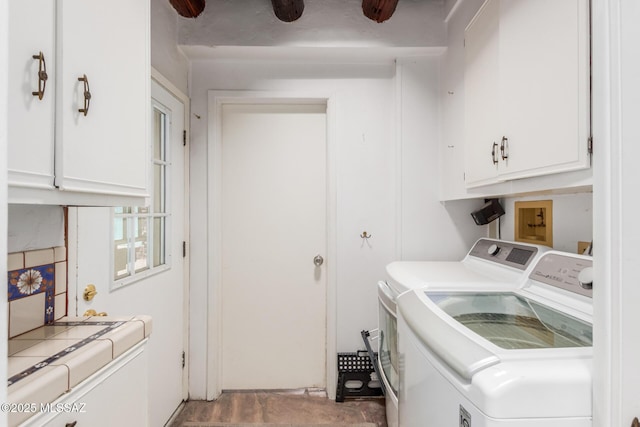 washroom featuring separate washer and dryer and cabinet space