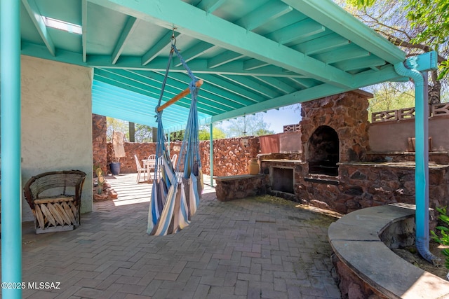 view of patio / terrace featuring an outdoor stone fireplace and a fenced backyard