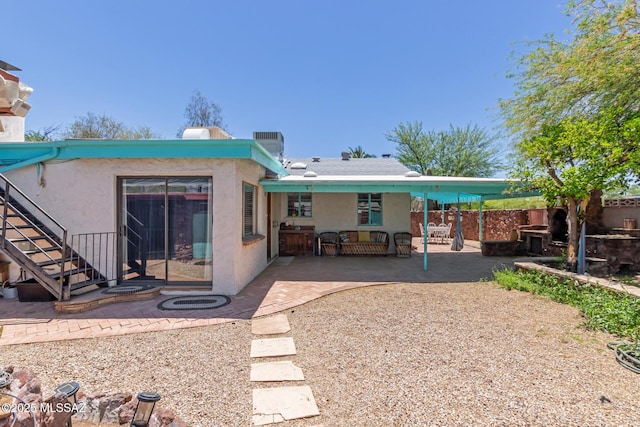 back of house featuring stucco siding, stairs, a patio, and fence