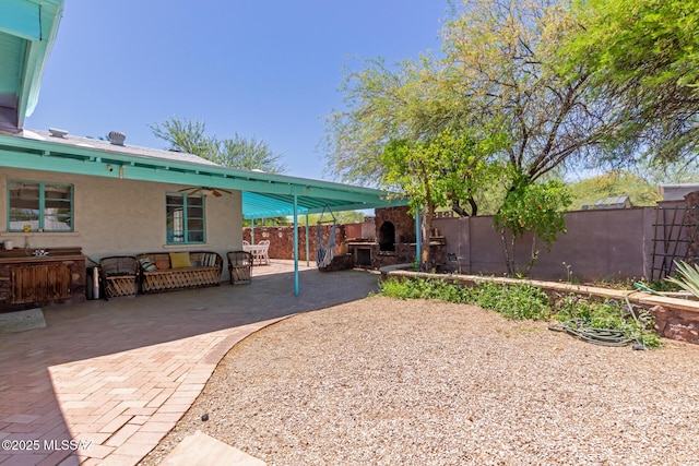 back of house with stucco siding, a patio area, a fenced backyard, and an outdoor living space with a fireplace