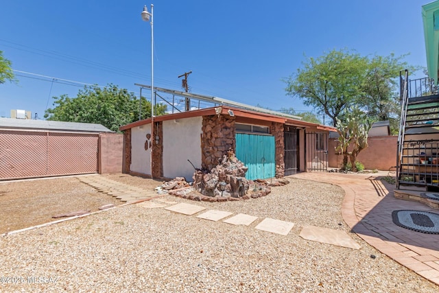 back of house with stairway, fence, a patio area, and stucco siding