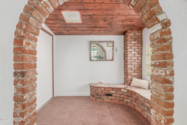 unfurnished room with tile patterned floors and wood ceiling