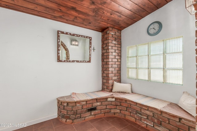 unfurnished room with dark tile patterned floors and wood ceiling