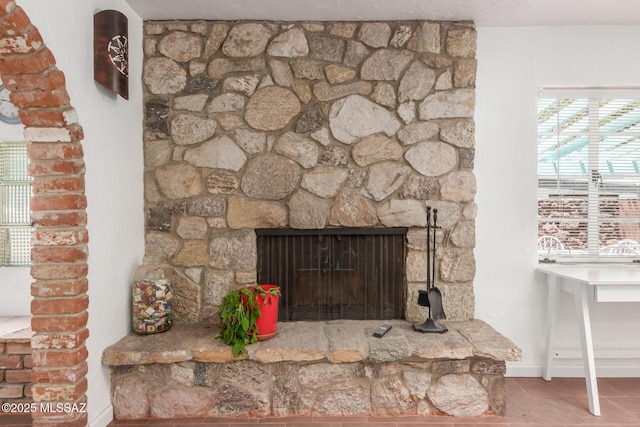 detailed view of baseboards and a stone fireplace