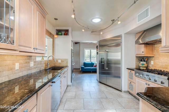 6261 N Placita De Rojelio, Tucson, AZ 85718 - kitchen with built in appliances, a sink, wall chimney exhaust hood, glass insert cabinets, and dark stone counters